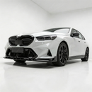 BMW M5 G90 with new SuperAutoUSA gloss black front lip parked in a detailing studio