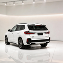 BMW X1 U11 with new gloss black rear roof spoiler parked in a detailing studio