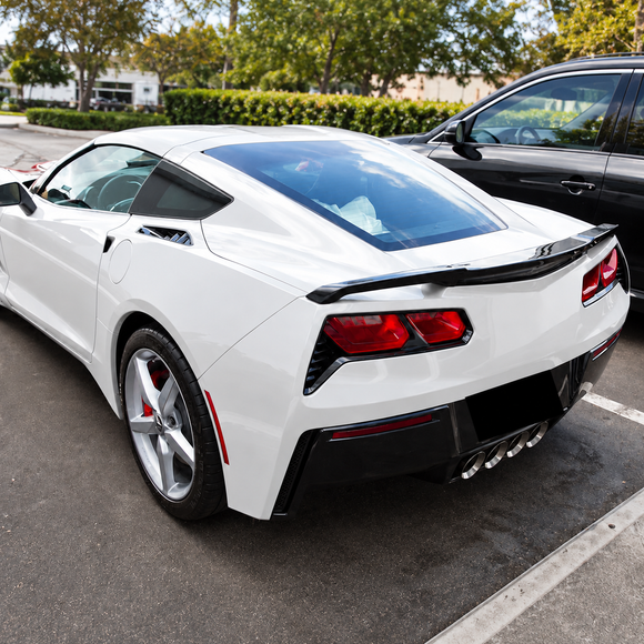 Aggressive OEM+ performance aesthetic of the gloss carbon look rear spoiler mounted on an Arctic White Corvette C7