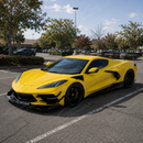 High-contrast visual transformation of the extended front splitter assembly on an Arctic White Corvette C8