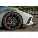 Three-quarter track perspective showing the extended front lip splitter hugging a low-profile wheel fitment on a Corvette C8