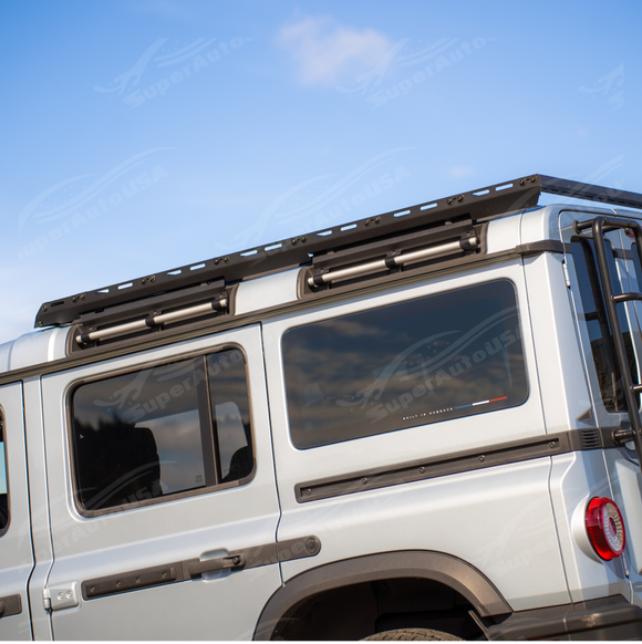 An overland-ready 2026 INEOS Grenadier with a rooftop tent secured to the cross bar carrier system.