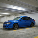 Classic World Rally Blue Subaru STI with the SuperAutoUSA carbon fiber print front splitter upgrade