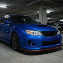Full 3/4 view of a 2009 Subaru STI with the SuperAutoUSA red-accented carbon fiber print front lip kit