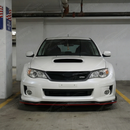 Full 3/4 view of a 2012 Subaru STI with the red-accented gloss black front lip kit