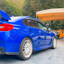 Low-angle perspective highlighting the sleek, ground-hugging profile of the gloss black JDM extensions
