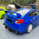 Gloss black rear diffuser fins providing aggressive contrast on a World Rally Blue Subaru STI