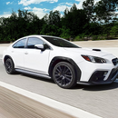 Glossy real carbon fiber rear fender flares contrasting sharply with the white paint of a 2023 Subaru WRX VB