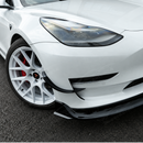 High-gloss black SuperAutoUSA VTEN 1-piece front lip creating a sharp contrast on a Pearl White Multi-Coat Tesla Model 3