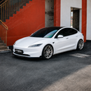 High-gloss black SuperAutoUSA VTEN 1-piece front lip creating a sharp contrast on a Pearl White Multi-Coat Tesla Model 3